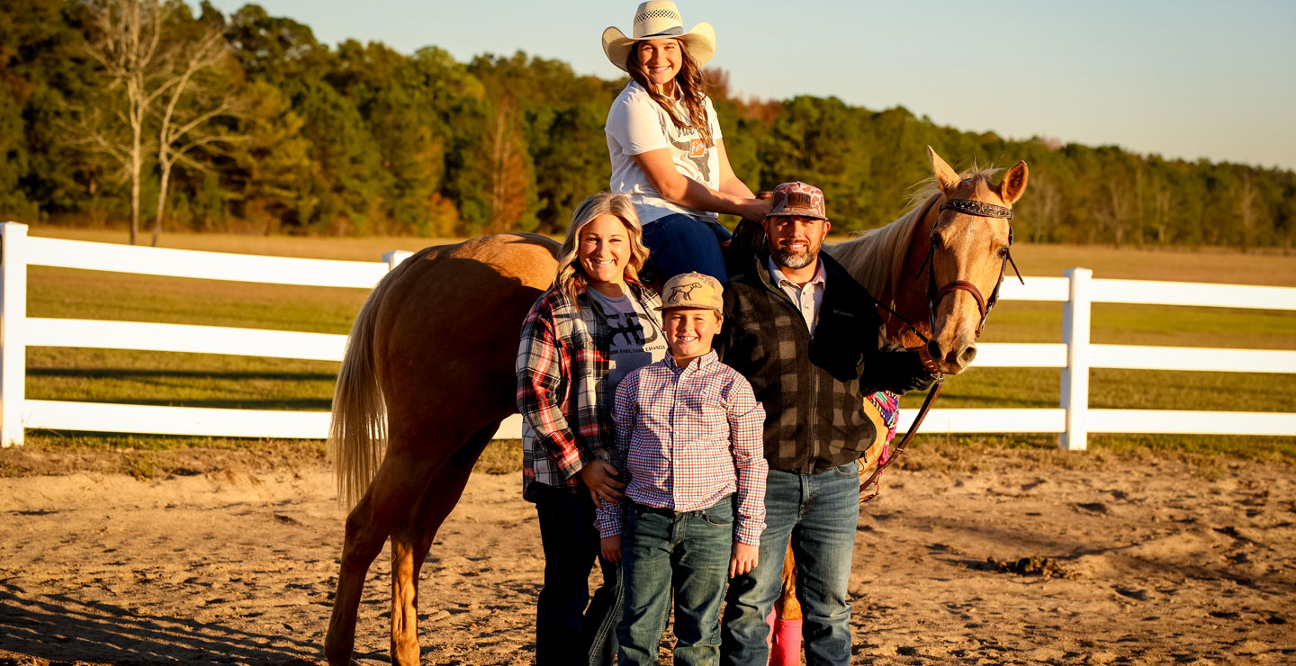 The Nipper family posing next to Ella and her palomino horse. 